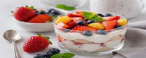Yoghurt met aardbeien en blauwe bessen in een glazen kom