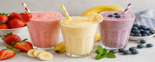 Fruit milkshakes met aardbei, banaan en blauwe bes in een glas